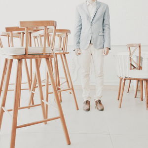 Low section of man standing by chairs