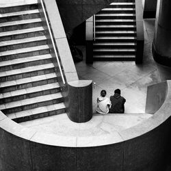 High angle view of friends sitting on steps