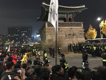 Crowd at illuminated city against sky at night