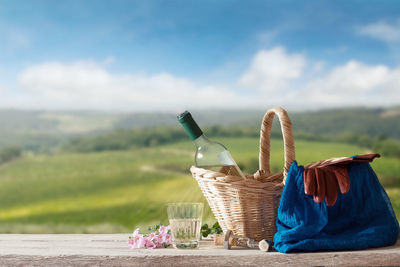 View of wicker basket on table by land against sky