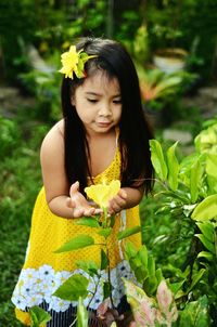 Rear view of woman holding flower