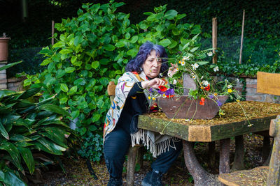 Senior woman with flower basket in the garden