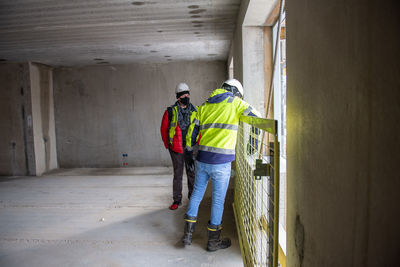 Architect of building project and the construction manager walk around interior of the new building