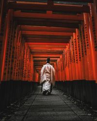 Rear view of man walking in corridor