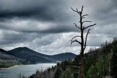 Scenic view of lake and mountains against cloudy sky