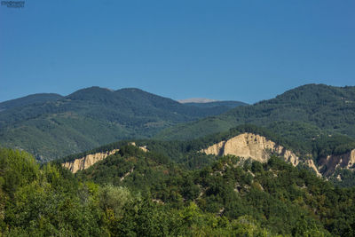 Scenic view of mountains against clear blue sky