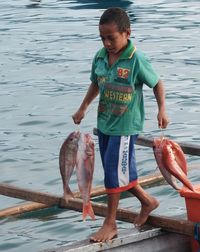 Full length of boy standing in sea