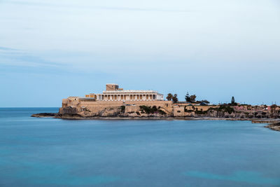 Building by sea against sky