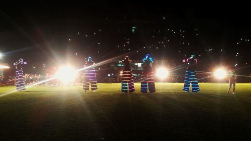 Illuminated road against sky at night