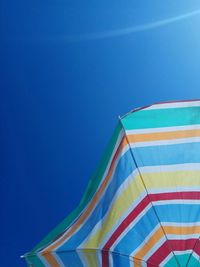 Low angle view of beach umbrella against clear blue sky
