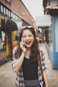 Smiling young woman standing against wall