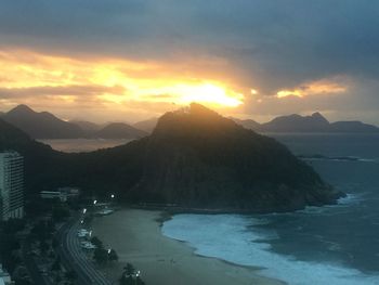 Scenic view of sea and mountains against sky during sunset