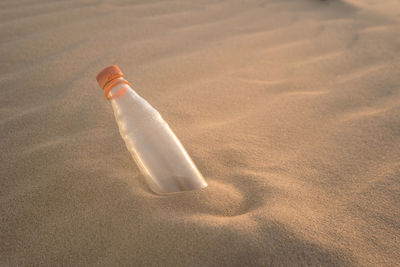 High angle view of bottle on sand at beach