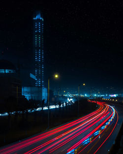 Light trails on road against sky at night