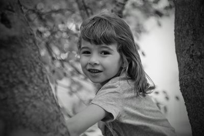 Close-up portrait of cute girl amidst trees