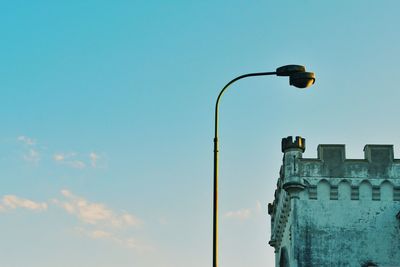 Low angle view of street light and historic building against sky