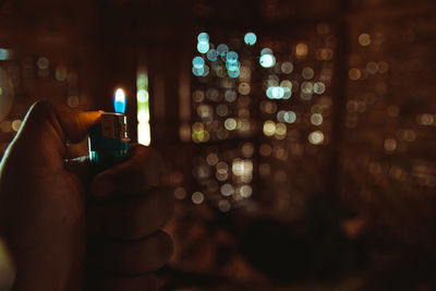 Close-up of hand holding lit candles