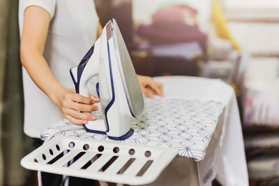 Midsection of woman using mobile phone on table