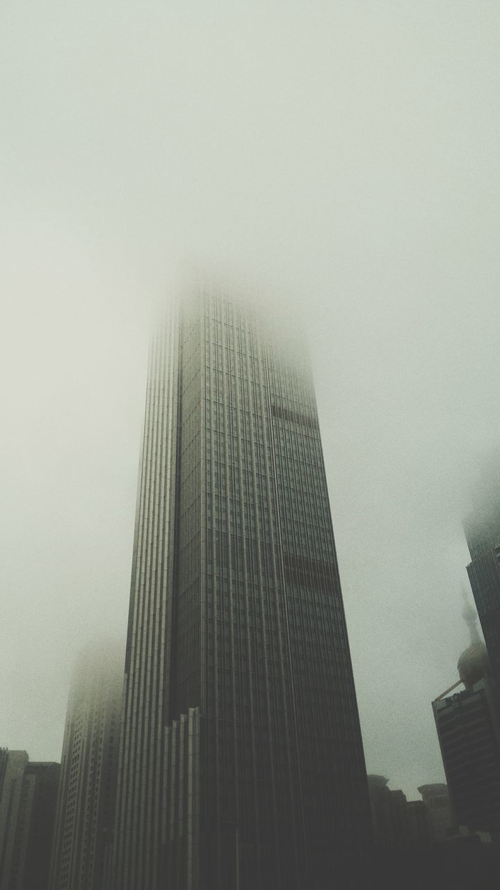 architecture, building exterior, built structure, skyscraper, city, office building, tall - high, modern, fog, low angle view, building, tower, sky, copy space, weather, foggy, day, glass - material, outdoors