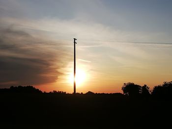 Silhouette street against sky during sunset