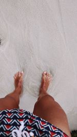 Low section of man relaxing on beach