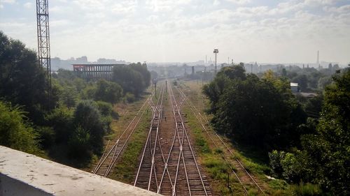 Railroad tracks amidst trees against sky