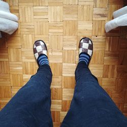 Low section of man standing on hardwood floor