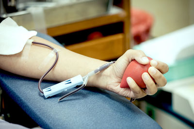 Cropped hand of patient holding stress ball in hospital