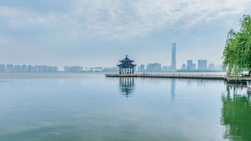 View of buildings in city against cloudy sky