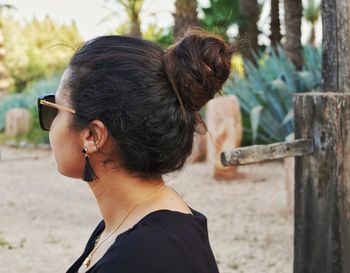 Rear view of senior woman holding sunglasses