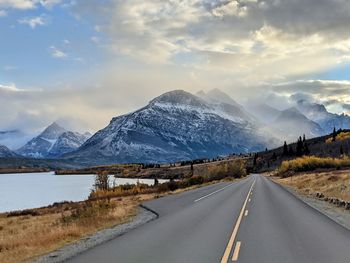 Road amidst snowcapped mountains against sky