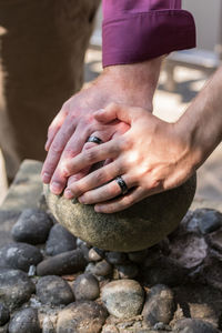 Close-up of hands touching rock