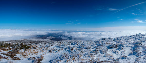 Scenic view of snowcapped mountains against blue sky