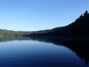 Scenic view of lake against clear blue sky