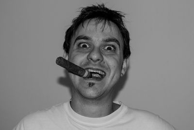 Portrait of man with cigar against wall at home