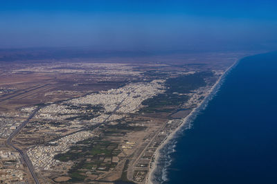 Oman, dhofar governorate, salalah, aerial view of desert city and coastline of persian gulf