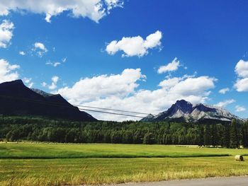 Scenic view of field and mountains against sky