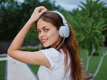 Portrait of young woman with eyes closed headphones