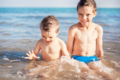 Brother having fun in waves at beach