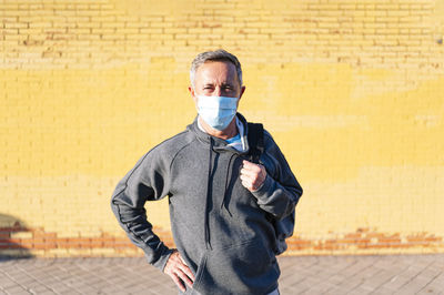 Portrait of man standing against wall