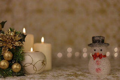 Close-up of christmas decorations with candles on table