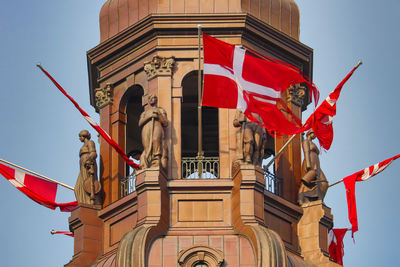 Low angle view of flag on building against sky