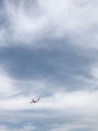 Low angle view of airplane flying against sky