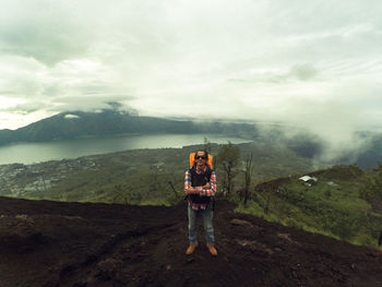Man standing on mountain against sky