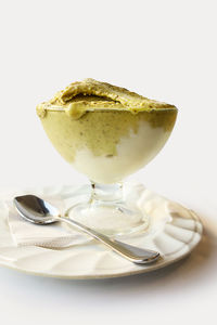 Close-up of ice cream in plate against white background