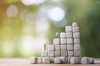 Backpacker miniature people on cube rock with bokeh nature background,tourism concept