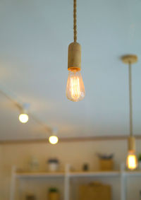 Low angle view of illuminated light bulb against sky