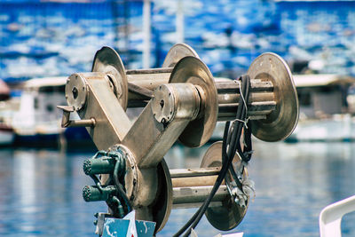 Close-up of machine part by sea