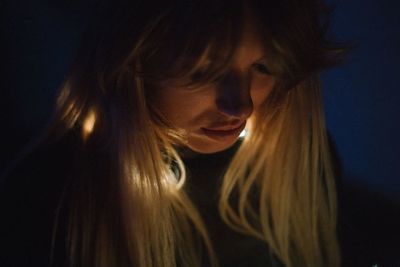 Close-up of young woman with long hair in darkroom