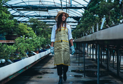 Full length portrait of young woman standing on bridge